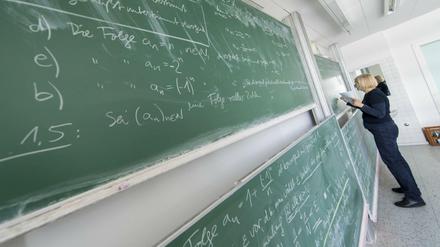 Eine Mathematik-Dozentin rechnet an der Tafel.