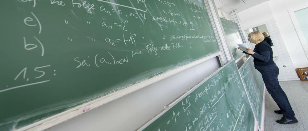 Eine Mathematik-Dozentin rechnet an der Tafel.