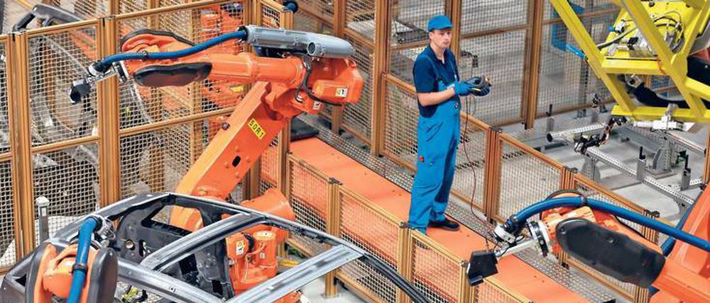 Suchbild. Menschen sind in der Karosseriebau-Halle des Leipziger BMW-Werks kaum zu finden. Es dominieren die Greifarme der Kuka-Roboter, die Leichtbauteile zusammenfügen. Die Mitarbeiter kontrollieren nur noch die Produktion der Elektroautos. Foto: Woitas/dpa