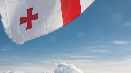 Gipfelkreuz. Die georgische Flagge dient als Sonnenschutz.