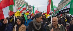 Demonstranten stehen am auf dem Pariser Platz in Berlin und protestieren gegen das iranische Regierungssystem.