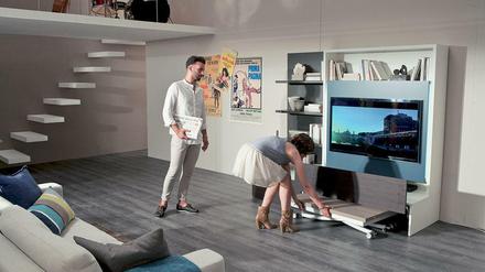 Die Schrankwand "Smart Living" von Ozzio hat ein cleveres Versteck: In der Lade verbirgt sich ein Klapptisch.