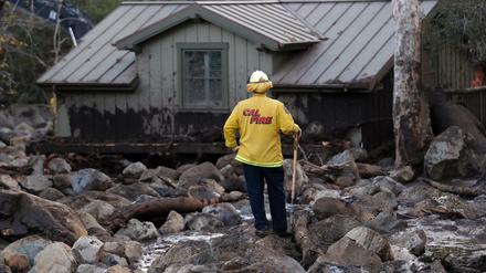 Eine Einheit der Feuerwehr steht am 10.01.2018 in Montecito, Kalifornien, USA, zwischen Geröll und Schlamm vor einem Haus. 