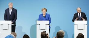 Der CSU-Vorsitzenden Horst Seehofer (l), der SPD-Parteivorsitzende Martin Schulz (r) und Bundeskanzlerin Angela Merkel (CDU) nehmen am 12.01.2018 im Willy-Brandt-Haus in Berlin an einer Pressekonferenz teil. Die Spitzen von CDU, CSU und SPD streben eine Neuauflage der großen Koalition an.