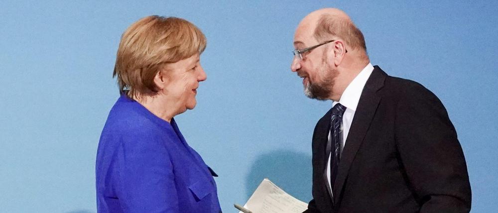 Martin Schulz, Vorsitzender der Sozialdemokratischen Partei Deutschlands (SPD) und Angela Merkel, Bundeskanzlerin und Vorsitzende der Christlich Demokratischen Union (CDU), reichen sich am 12.01.2018 am Ende der Sondierungen von Union und SPD im Willy-Brandt-Haus in Berlin die Hände.