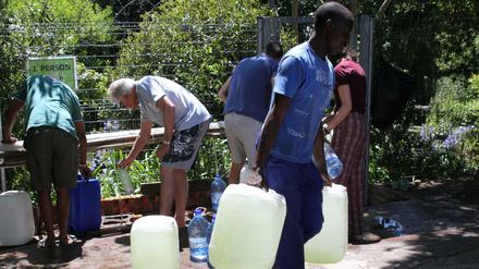 Bürger füllen ihre Wasserkanister an einer natürlichen Quelle in Kapstadts Vorort Newlands auf.