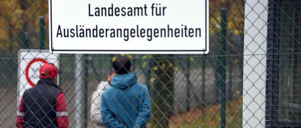 Drei junge Männer stehen in Boostedt (Schleswig-Holstein) am Zugang zu der Erstaufnahmeeinrichtung.