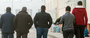 Asylbewerber gehen über das Gelände der Zentralen Ausländerbehörde (ZABH) in Eisenhüttenstadt (Brandenburg).