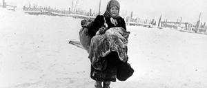 Eine Frau betrauert von deutschen Besatzern erhängte Männer.