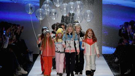 Kinder mit Luftballons in der Hand liefen über den Laufsteg, dazu fiel Kunstschnee von der Decke herunter.