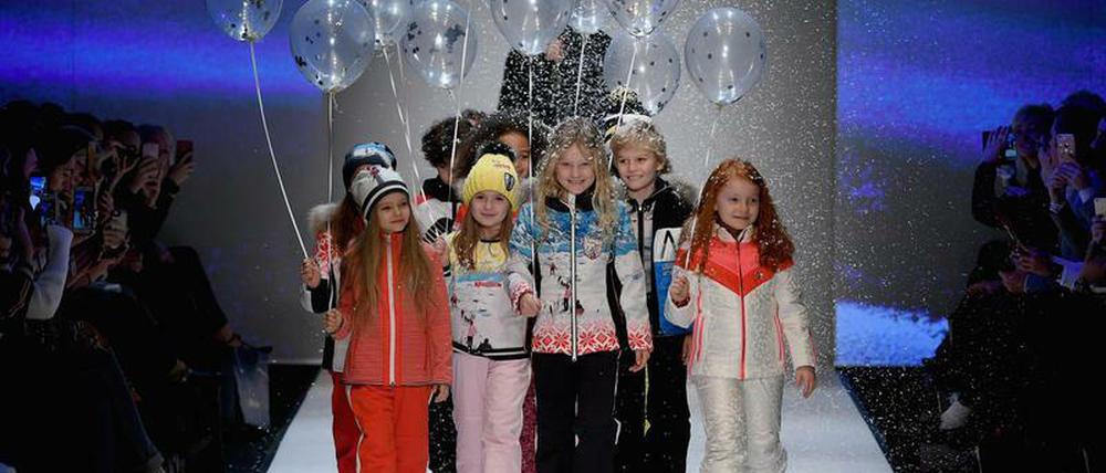 Kinder mit Luftballons in der Hand liefen über den Laufsteg, dazu fiel Kunstschnee von der Decke herunter.