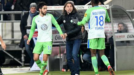 Wolfsburgs Yunus Malli (l) bejubelt sein Tor zum 1:0 gegen Hannover 96 mit Victor Osimhen (r) und Wolfsburgs Trainer Martin Schmidt (M). 