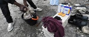 Ein Flüchtling - hier nicht in Ungarn, sondern am Rande von Marseille - wäscht in einem Eimer auf der Straße seine Wäsche. 