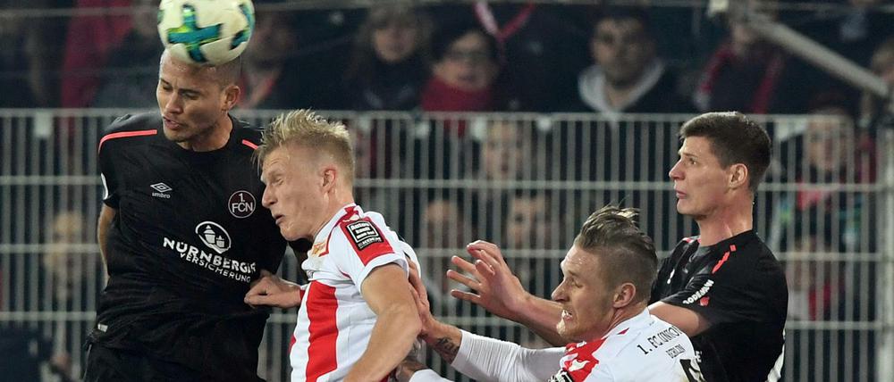 Kristian Pedersen (2.v.l) und Sebastian Polter (2.v.r) vom 1.FC Union Berlin und Ewerton (l) und Patrick Erras (r) vom 1.FC Nürnberg kämpfen um den Ball.