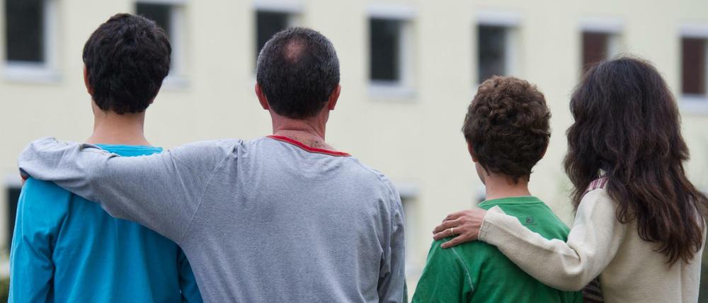 Vereint - ein Vater aus Syrien sitzt mit seinen drei Kindern vor einem Asylwohnheim. 