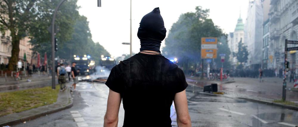 Ein Aktivist mit Steinen in den Händen steht am 07.07.2017 im Schanzenviertel in Hamburg. 