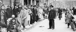 Untergang und Hoffnung. Menschen stehen im zerbombten Berlin Schlange, der Schwarzmarkt blüht.