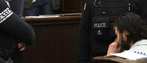 Elitepolizisten bewachen den Angeklagten.