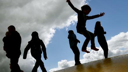 Kinder auf einer Hüpfburg. Das Armutsrisiko von Familien erhöht sich mit jedem Kind.