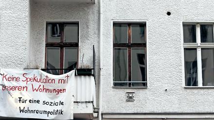 Ein Transparent gegen Wohnungsspekulationen hängt an einer Fassade eines Mietshauses in Berlin.