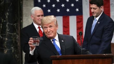 US-Präsident Donald Trump hält ein Glas Wasser während seiner Rede "Zur Lage der Nation" in die Kamera.