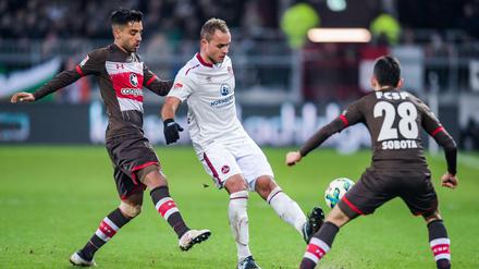 St. Paulis Sami Allagui (l-r), Nürnbergs Ewerton und St. Paulis Waldemar Sobota kämpfen um den Ball. 