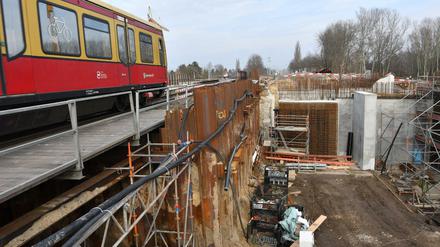 Eine S-Bahn passiert eine Brückenbaustelle am Karower Kreuz.