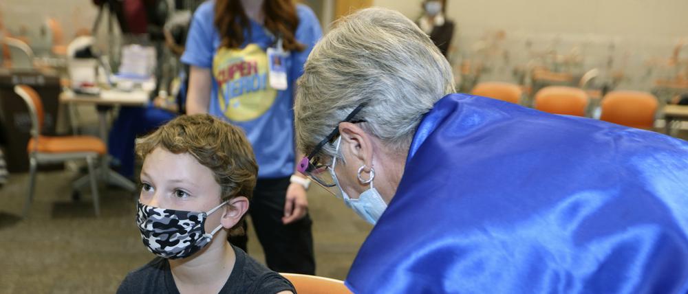 Jackson Stukus (l, 11 Jahre alt) erhält einen Covid-19-Impfstoff von Pfizer in den USA.