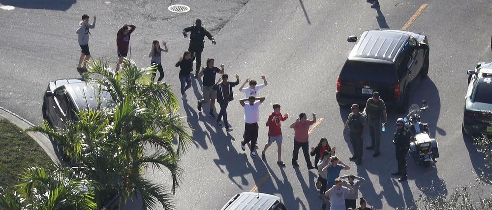 Begleitet von Polizisten verlassen Schüler der Marjory Stoneman Douglas High School in Parkland das Schulgebäude.