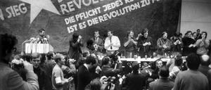 Etwa 3000 Personen, meist Studenten, nehmen an der vom Sozialistischen Deutschen Studentenbund (SDS) durchgeführten "Internationalen Vietnam-Konferenz" in der TU teil. Auf dem Bild vor einer übergroßen Vietkong-Fahne am Tisch stehend sind zu sehen - von links: K.D. Wolff (am Rednerpult), Dr. Klaus Meschkat, Dr. Johannes Agnoli, Christian Semmler, Gaston Salvatore, Rudi Dutschke, Günther Ament, Kurt Steinhaus und Tariq Ali.