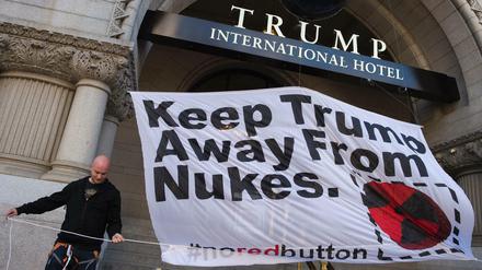 Ein Aktivist vor dem Trump International Hotel in Washington mit einem Banner, das vor Donald Trumps Atomplänen warnt. 