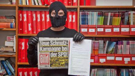 Auf der "Titanic"-Homepage posiert ein Vermummter mit der "Bild"-Ausgabe und den angeblichen Mails. 