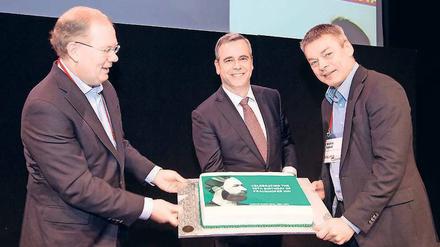 Tagesspiegel-Herausgeber Sebastian Turner überreicht den Leitern des Fraunhofer Heinrich-Hertz-Instituts (HHI) Thomas Wiegand und Martin Schell (v.l.) zum 90.Geburtstag eine Torte. 