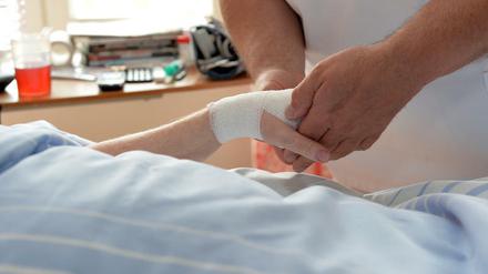Zu wenig Personal im Krankenhaus. Ein Pfleger betreut eine Patientin auf einer Palliativstation.