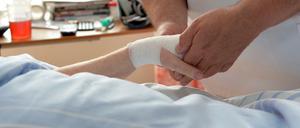 Zu wenig Personal im Krankenhaus. Ein Pfleger betreut eine Patientin auf einer Palliativstation.