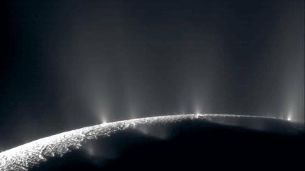 Sprühend vor Leben? Fontänen zeugen von einem Ozean unter dem Eis des Saturnmonds Enceladus. Irdische Bakterien könnten dort überleben.