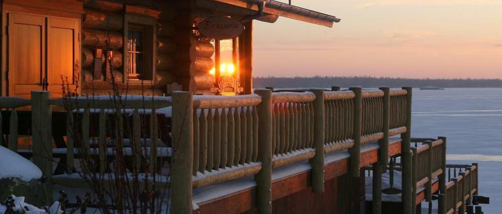 Sonnenuntergang auf der Terrasse mit Blick auf den winterlichen See.