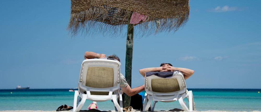 Urlauber am Strand an der Platja de Muro im Norden Mallorcas.