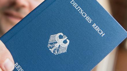 Gefährliche Reichsbürger: Ein Mann hält ein Heft mit dem Aufdruck «Deutsches Reich Reisepass» in der Hand.