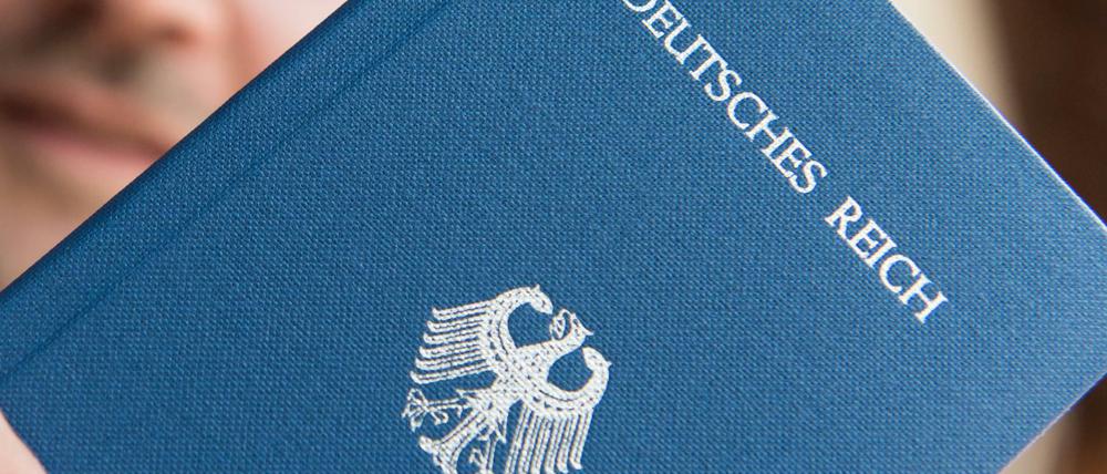 Gefährliche Reichsbürger: Ein Mann hält ein Heft mit dem Aufdruck «Deutsches Reich Reisepass» in der Hand.