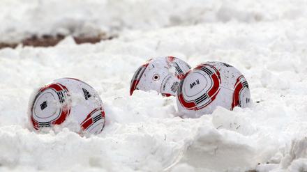 Fußbälle im Schnee. 