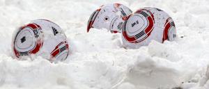 Fußbälle im Schnee. 