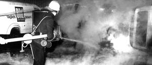 Löscharbeiten vor der Fahrzeug-Wartungshalle des Springer-Hochhaus in Berlin am 13. April 1968. 