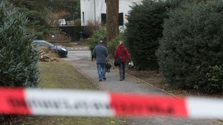 Polizisten suchen mit einem Spürhund Spuren des Säure-Attentats.