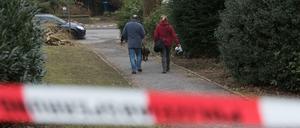 Polizisten suchen mit einem Spürhund Spuren des Säure-Attentats.