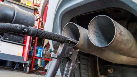 Eine Sonde eines Gerätes zur Abgasuntersuchung für Dieselmotoren steckt im Auspuffrohr eines VW Golf.