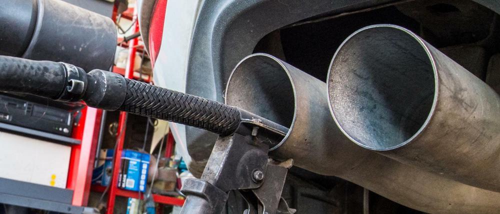 Eine Sonde eines Gerätes zur Abgasuntersuchung für Dieselmotoren steckt im Auspuffrohr eines VW Golf.