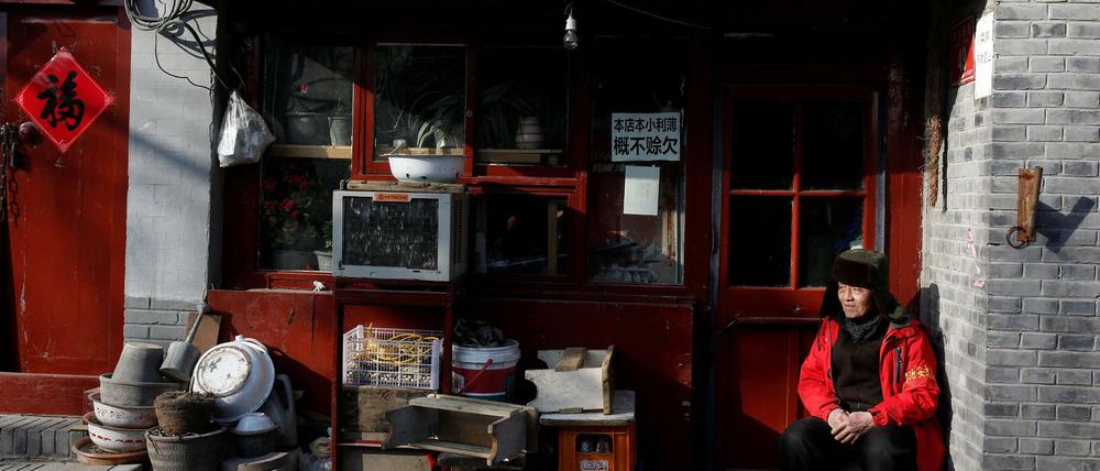Ein freiwilliger Helfer beobachtet während des Volkskongresses in einer Pekinger Hutonggasse die Umgebung.