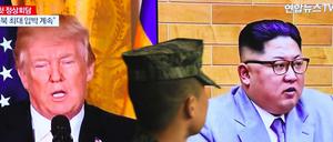 Ein südkoreanischer Soldat geht an einem Bildschirm vorbei auf dem US-Präsident Donald Trump und Nordkoreas Führer Kim Jong Un zu sehen sind.