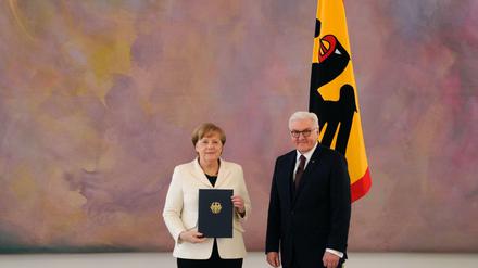 Angela Merkel mit der Ernennungsurkunde zu ihrer vierten Kanzlerschaft mit Bundespräsident Frank-Walter Steinmeier.